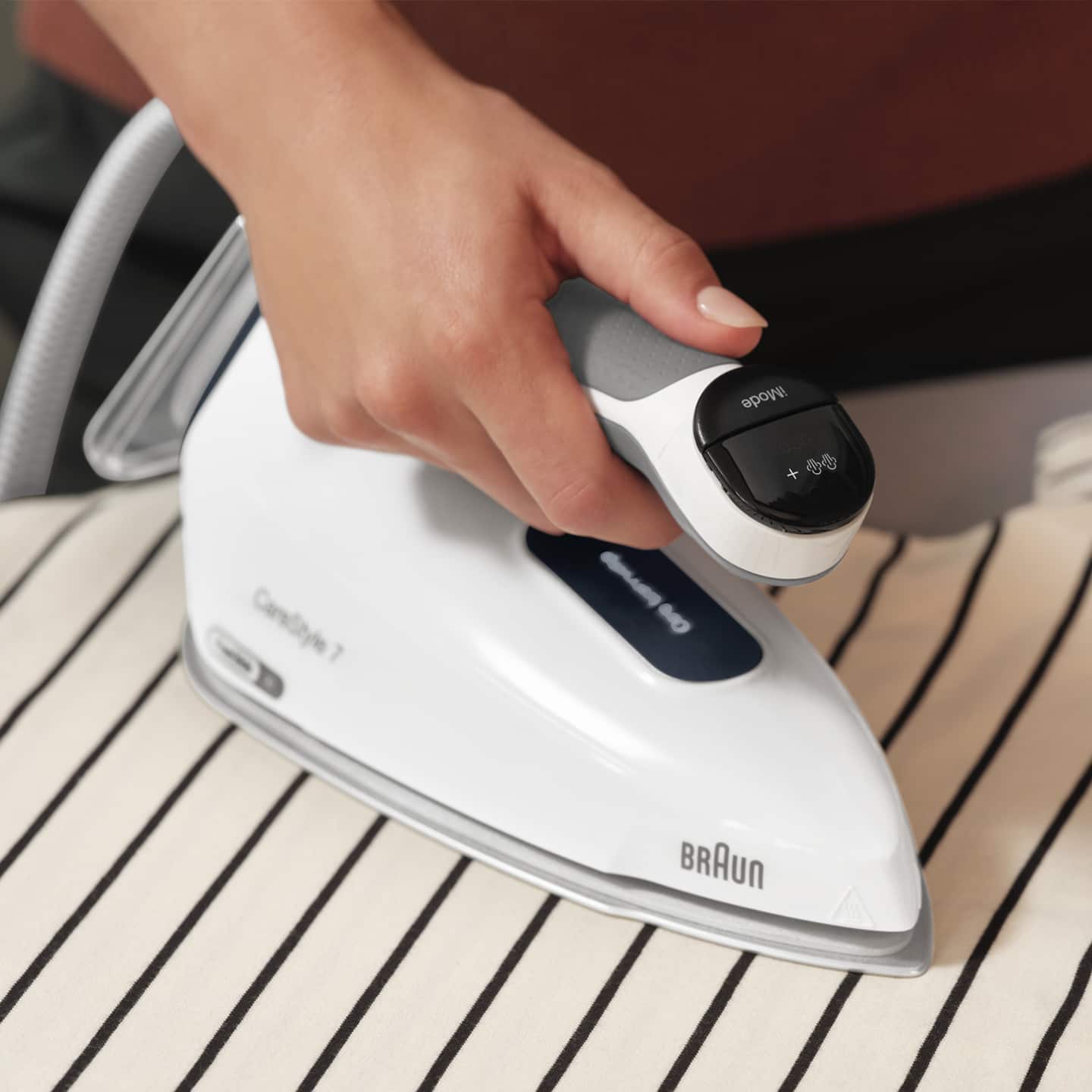  A person ironing a shirt with Braun CareStyle 7 iron.
