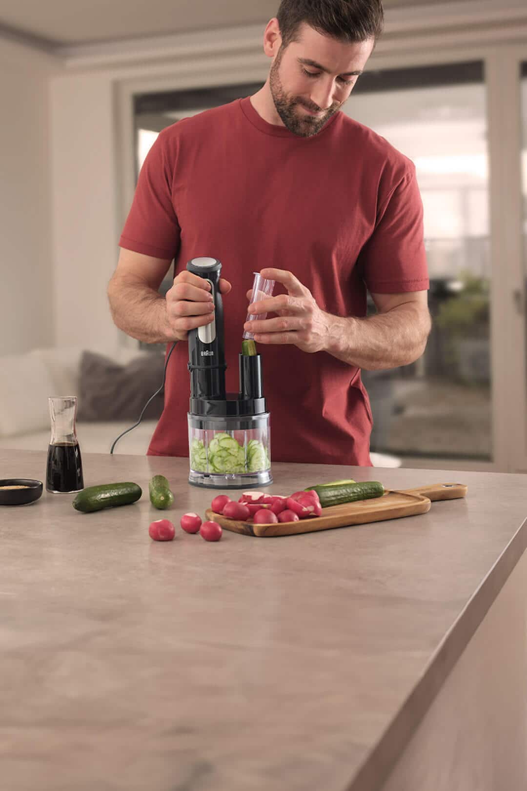 A man slices a cucumber using the Braun MQ 5 Pro Hand blender and the Mini Food Processor Attachment.