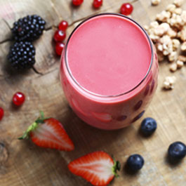 Red fruit-banana smoothie with granola and soy milk