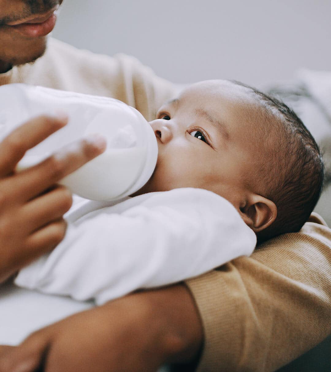 Man feeding a baby with a milk bottle 