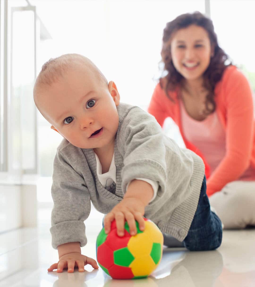 Woman and baby playing with a toy ball