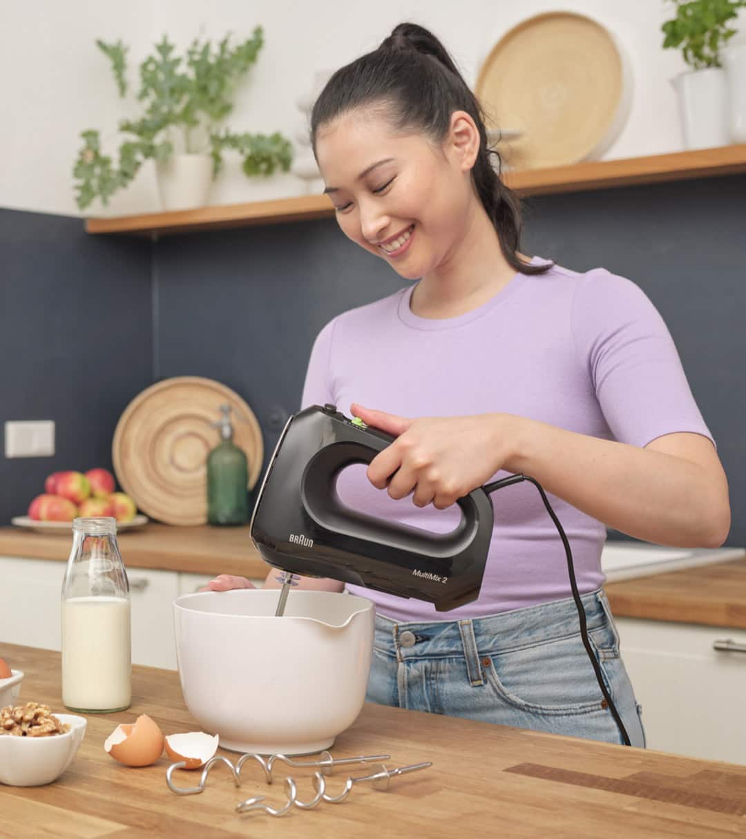 Woman using a black MultiMix 2 hand mixer that has 4 speeds and an additional turbo mode