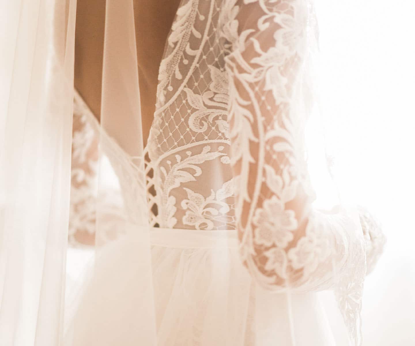 Kobieta w zdobionej koronkami i aplikacjami sukience ślubnej - zdjęcie