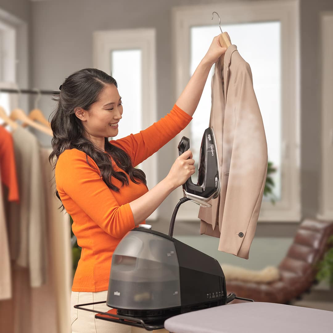 Woman ironing a jacket vertically