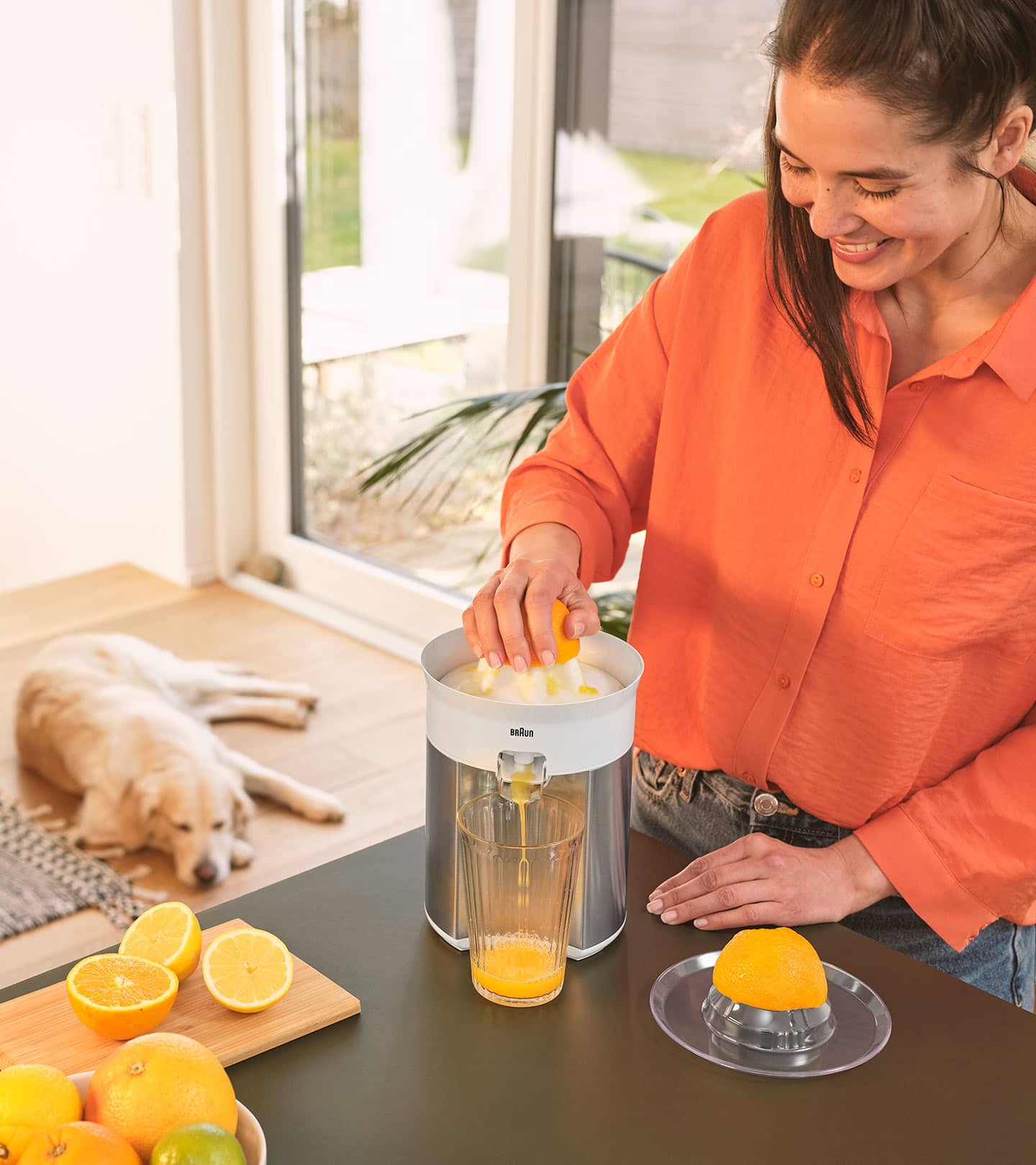 Woman squeezing fresh orange juice with Braun CitrusQuick 5 Citrus juicer 